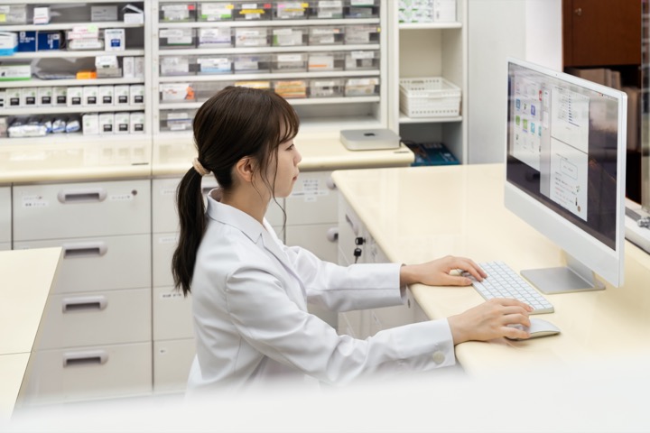 薬局内のMacで業務データを確認する薬剤師