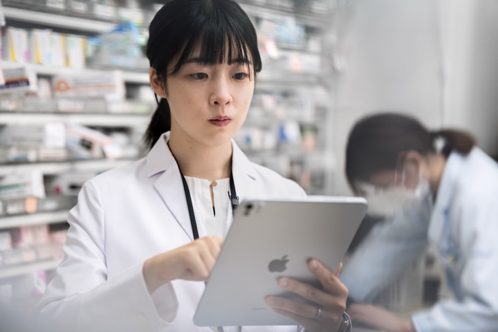 薬局内でiPadを使って業務する薬剤師